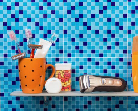 Hygiene bath tools on bathroom shelf. Blue background